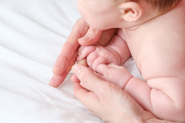 宝宝的脚在妈妈的手里。婴儿按摩概念。一个小新生儿的脚在一个女性的手形状近距离。妈妈和孩子图片下载