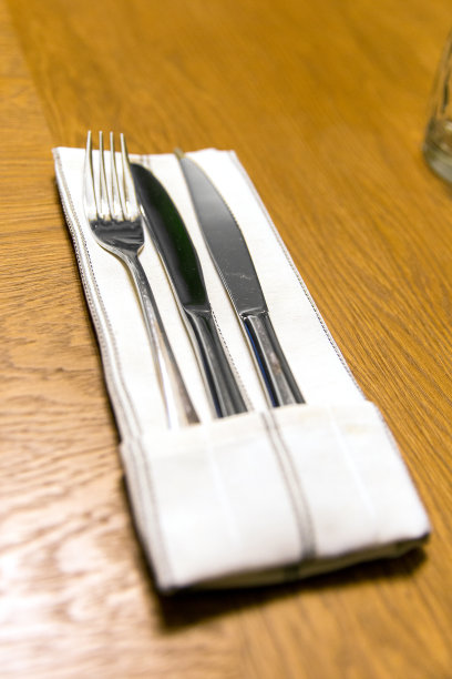 特写:白色餐巾上的两把刀叉图片下载