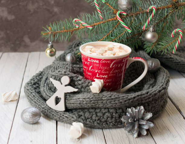 一杯热可可或巧克力，在编织的围巾和圣诞树的树枝的背景上放上棉花糖。圣诞节的传统饮料。图片下载