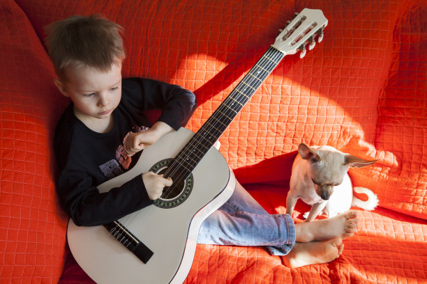 两兄弟学习弹原声吉他。图片下载