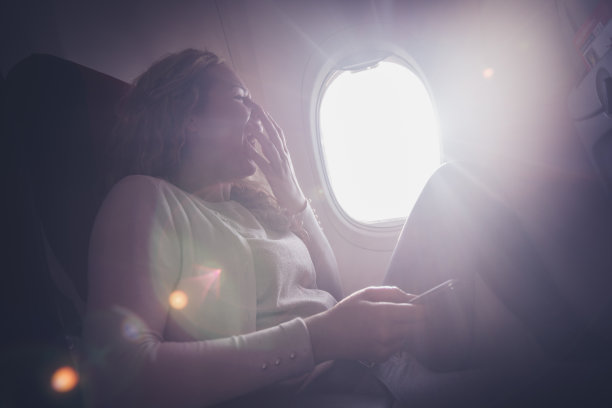 年轻的卷发女人打哈欠。图片下载