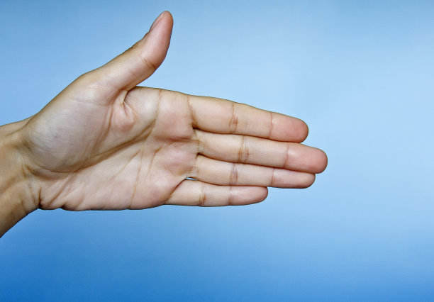 在蓝色背景下女性手孤立的特写图片下载