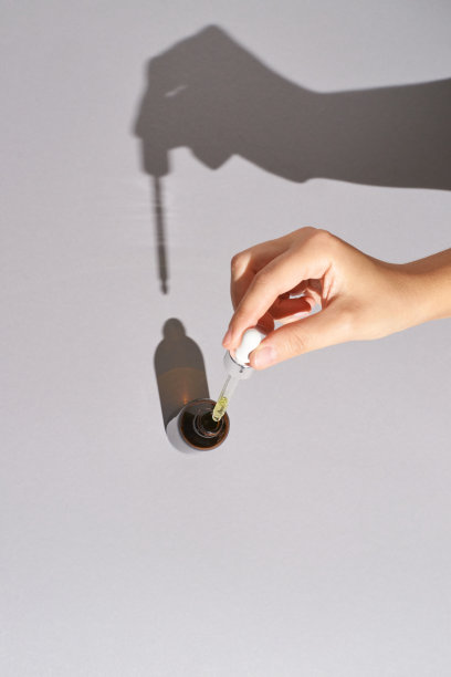 女人手持血清滴剂。硬阴影图片下载