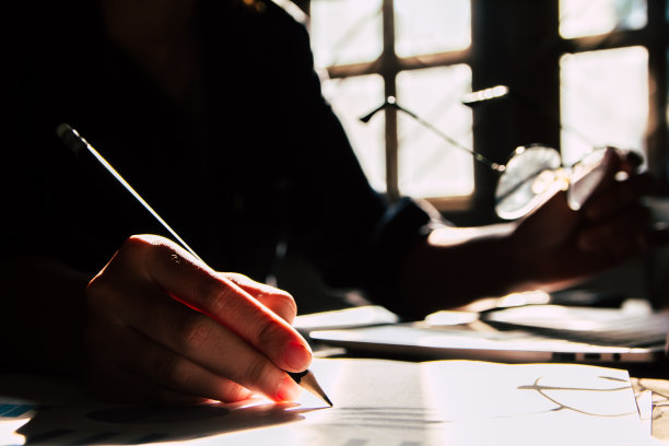 亚洲青年商人的学生拿着笔在纸上写一封信在家里。剪影照片图片下载