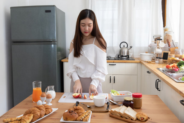 微笑的年轻亚洲妇女站在厨房，准备一个健康的面包，蔬菜和水果沙拉。照顾好你的健康、饮食、无谷蛋白的概念图片下载