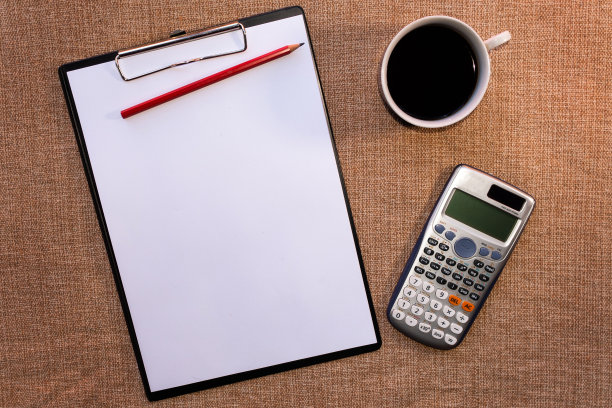 浅棕色的办公桌桌子与库存照片和设计与空白笔记本电脑，电脑，项目和一杯咖啡。顶部视图与复制空间。平坦的地板上。图片下载