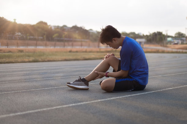 跑步者在跑步后受伤了。(他触到了小腿疼痛的地方。)图片下载