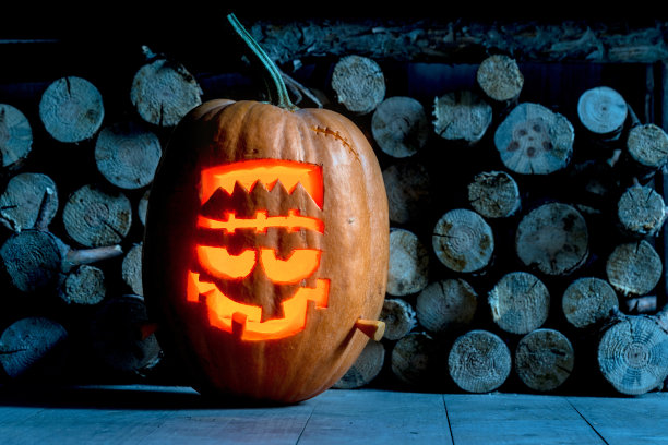 南瓜脸的万圣节近距离前堆栈的木头。万圣节的背景。素材图片