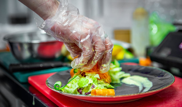 厨师手戴手套在厨房做蔬菜沙拉图片下载