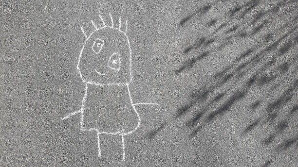 一个三岁小孩在人行道上用粉笔画的简单涂鸦图片下载