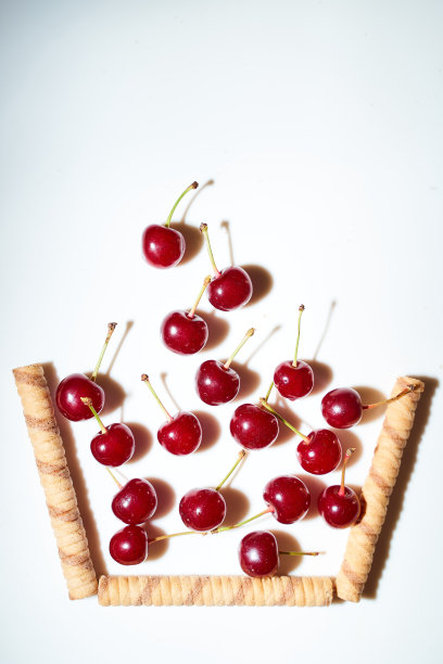 一组樱桃，白色背景和阴影。落在从巧克力棒概念照片的临时篮子。广告照片。俯视图图片下载