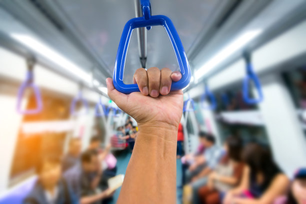 在模糊的背景下，乘客手握着火车的把手。图片下载