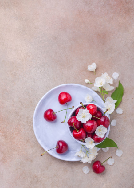 新鲜的甜樱桃和漂亮的白色花瓣放在碗里图片下载