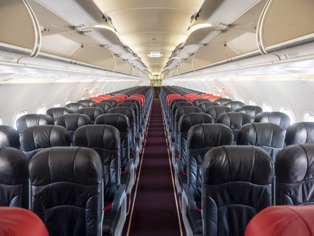 头等舱和经济舱的座位排。红色和黑色的座位。经济中突出红色溢价座位。图片下载