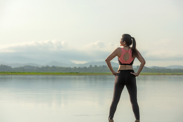 生活方式女性瑜伽练习和蚯蚓前举起手臂的姿势，为健康的生活。年轻女孩或人摆平衡身体，重要的禅和冥想锻炼和健身运动户外日出早晨。自然背景。卫生保健的概念图片下载
