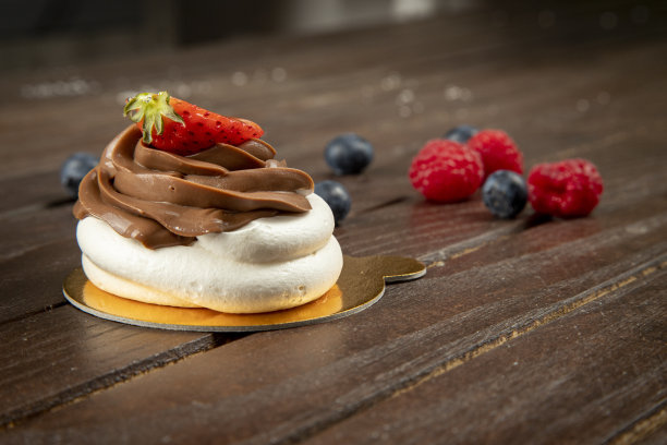 巴甫洛娃甜点在木制背景与复制空间。图片下载