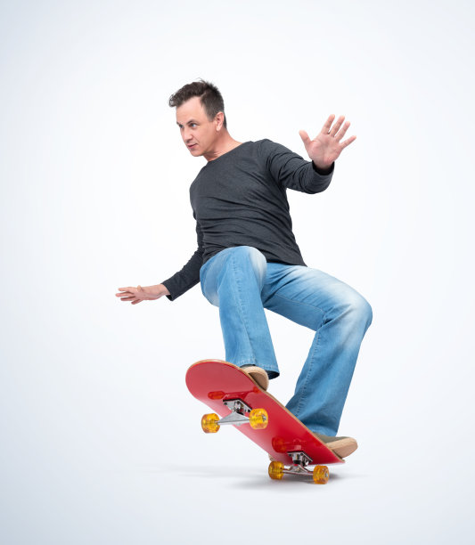 情绪化的男人穿着休闲的衣服在滑板上玩极端，孤立在光的背景。图片下载