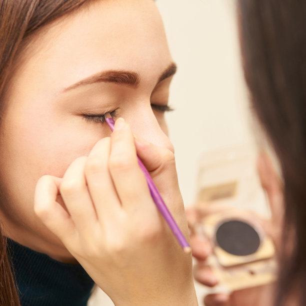 专业化妆师使用面部睫毛膏。女性美容模特。自然的样子。轮廓的基础图片下载