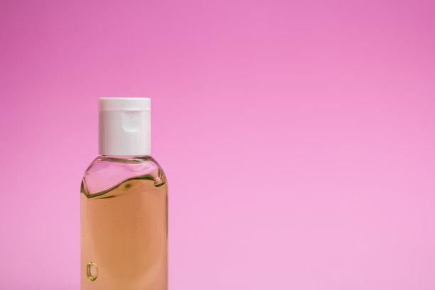 粉红色背景上的消毒瓶图片下载