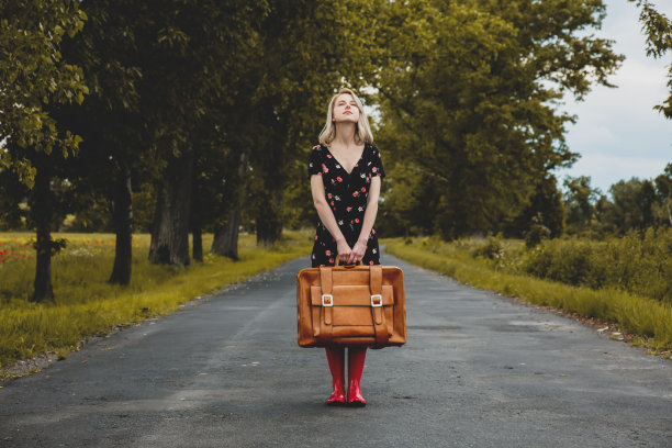 金发女孩穿着红靴子和在乡村道路图片下载