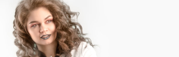 一个美丽的女人，一头美丽的又长又黑的卷发在风中飘扬。图片下载