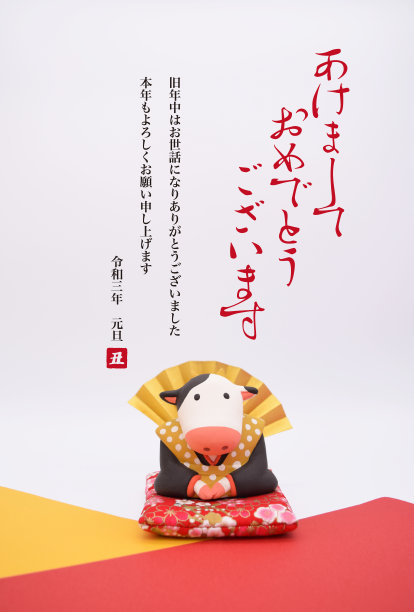 一张由日本传统人物福岛(Fukusuke)装扮的牛雕塑制作的新年卡片。这个雕塑是用粘土做的。图片下载