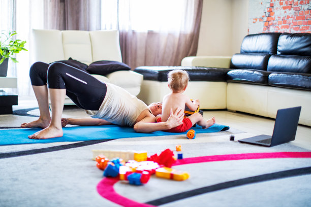年轻成年妇女在隔离期间在家带着婴儿锻炼图片下载