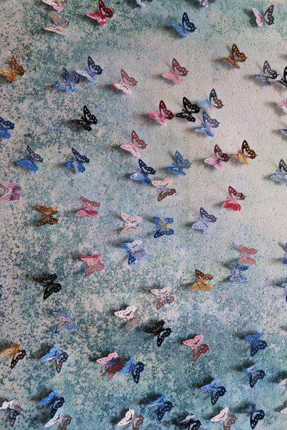 原工艺美术作品的图像裁剪出五彩缤纷的蝴蝶形状(帝王蝶-紫色，蓝色，橙色，粉红色和黑色的颜色)，彩色的艺术和工艺项目显示在墙上作为背景墙纸图片下载