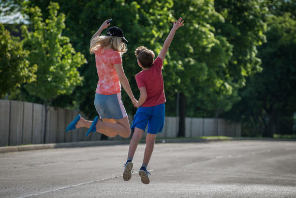 快乐的母子手牵着手边跳图片下载