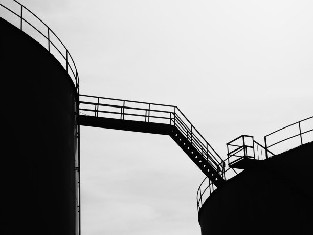 油气罐场连接两个储罐的天桥剪影。图片下载