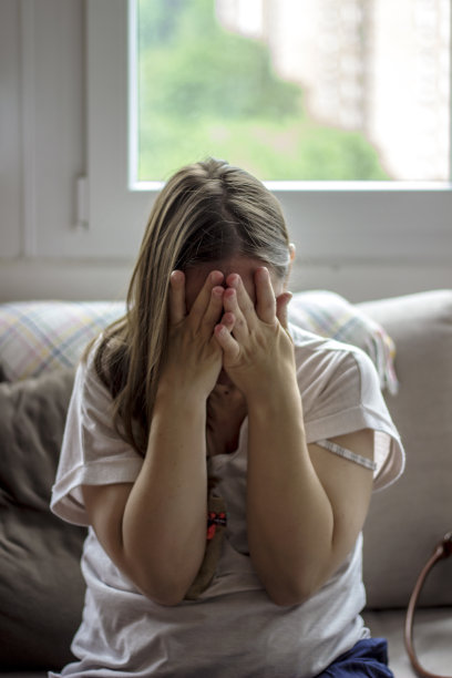 照片中的一个悲伤的女人举起手离开她的脸。图片下载