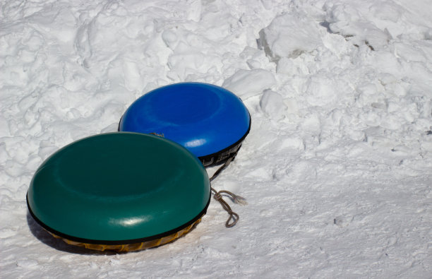 两个雪管(内管，保险杠管或甜甜圈，饼干)在雪背景。冬天用的带滑梯的充气雪橇。冬季活动休闲概念图片下载