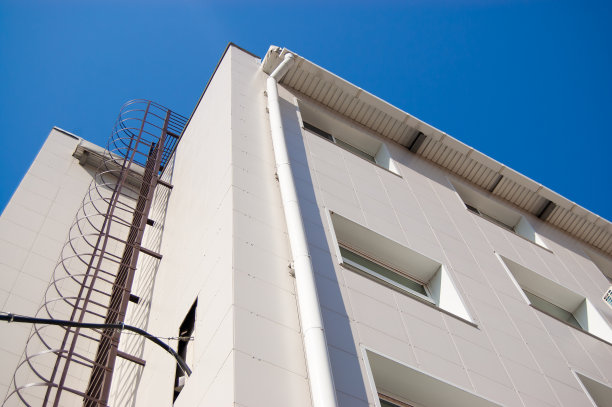 蓝色天空下的砖瓦建筑上的金属楼梯图片下载