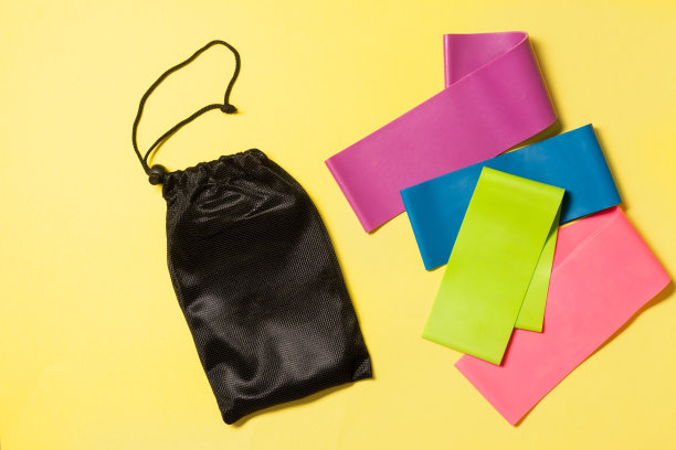 黄色背景的运动健身橡皮筋。运动器材。带有文本空间的俯视图图片下载