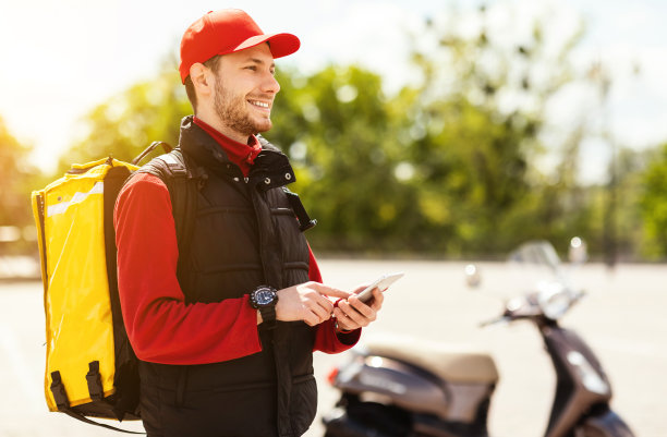 用智能手机踏板车在外面送餐图片下载