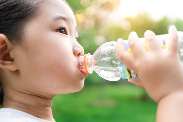 可爱的女孩喝一瓶水图片下载