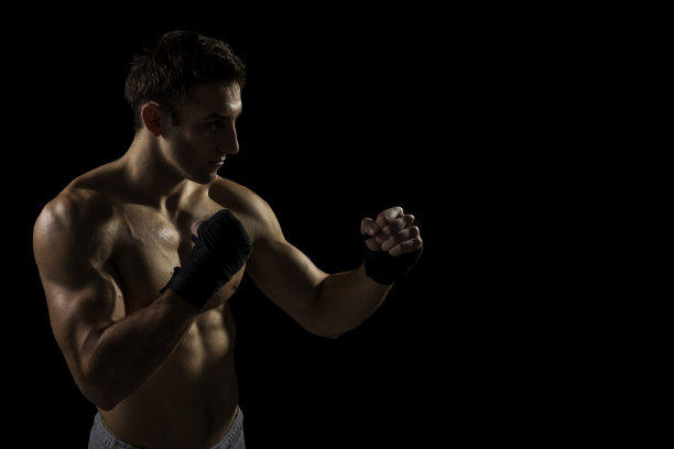 强大的肌肉拳击手。孤立在黑色背景上图片下载