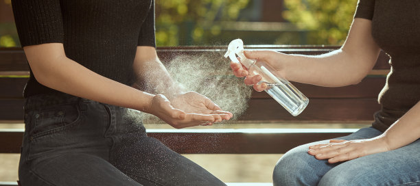 女人的手被消毒了女孩的手放在长凳的背景上。户外的照片。图片下载