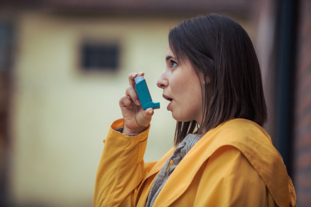 年轻女子使用哮喘吸入器图片下载