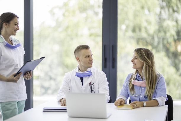 年轻微笑的护士和两位医生正在讨论病人的诊断库存照片图片下载