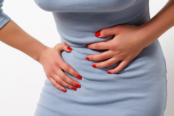 女孩在白色的背景上有胃痛。图片下载