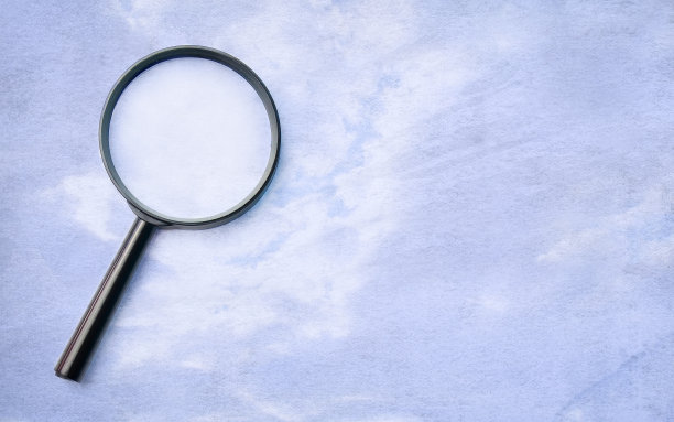 放大镜，在有蓝色污渍的牛皮纸上。图片下载