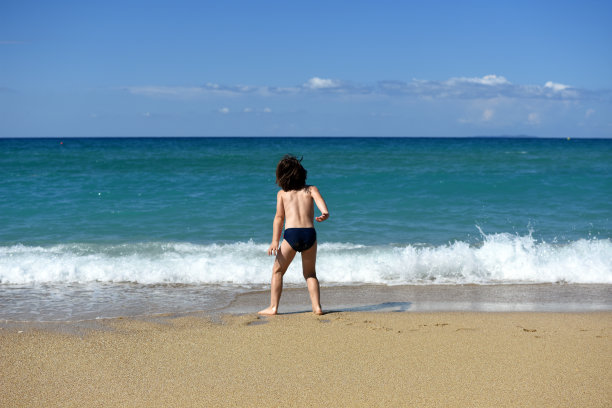 小男孩在海滩上享受图片下载