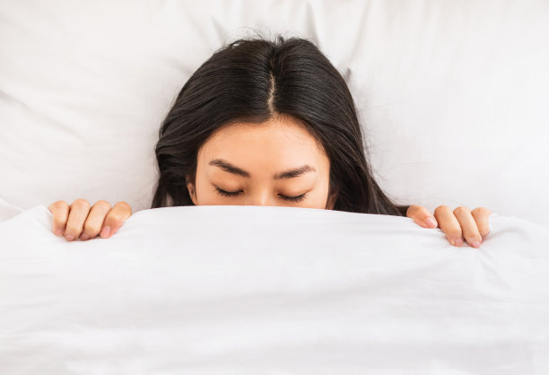 韩国女孩在床上盖着毯子睡觉，室内，俯视图图片下载