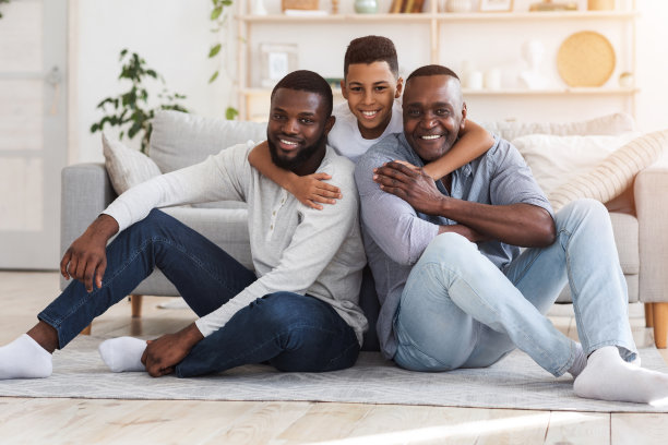 十几岁的非洲男孩，父亲和祖父坐在地板上对着镜头摆姿势图片下载