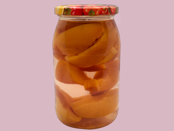 自制的水果果盘。玻璃罐里的蜜桃，粉红色背景。图片下载