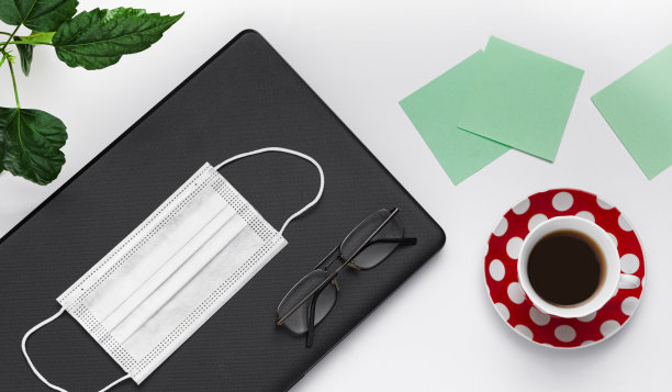 大流行期间的工作场所。计算机、咖啡、眼镜。图片下载