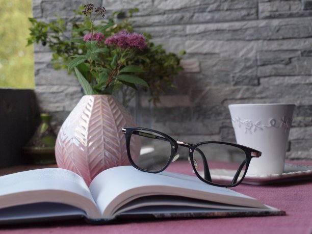 阳台上的咖啡桌上放着眼镜和一本书图片下载