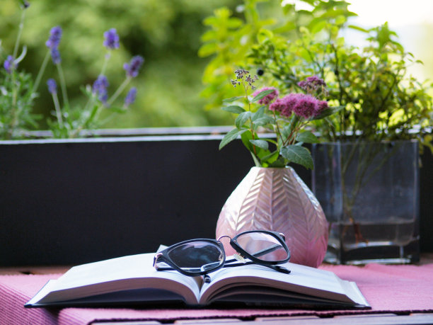 阳台上的咖啡桌上放着眼镜和一本书图片下载