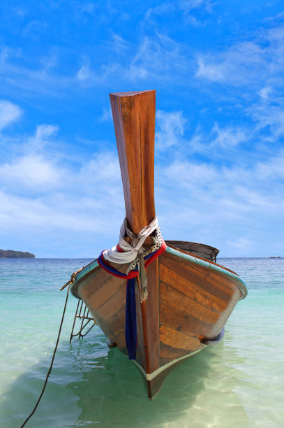 泰国南部的热带海洋，一艘长尾木船在碧绿的海水上图片下载